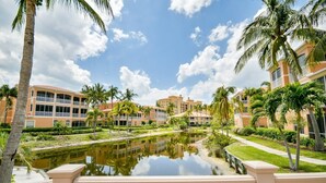 A resort with multiple-story buildings, a central water feature, and palm trees. - 3 Bedroom 2 Bath 2 Car Garage includes Golf Cart Usage (Punta Gorda)