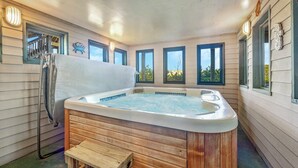 Ein Whirlpool in einem Raum mit Holzwänden und Fenstern.