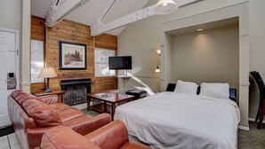 A hotel room with a bed, a sofa, a television, a fireplace, and a wooden wall. - Park City Resort Ctr 3BR 2Ba Walk2Ski; Free bus Main St; Hot Tub; Winter Pool (Park City)
