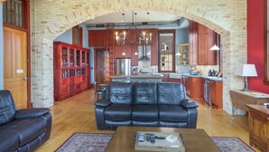 A living room with a black leather sofa, a wooden coffee table, and a red cabinet.