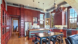 A spacious kitchen with wooden floors, a central island, and modern appliances.