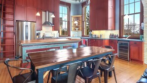 A spacious kitchen with a central island, wooden cabinetry, and modern appliances.