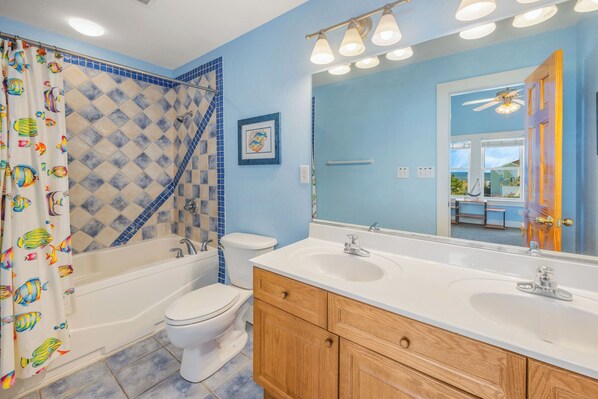 A bathroom with a bathtub, toilet, and double sink vanity. - Oceanview Home w/ Private Pool, Hot Tub, Elevator, Game Room, and Home Theater (Rodanthe)