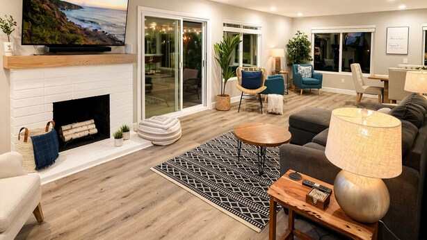 A modern living room with a fireplace, a television, and a large window overlooking a patio. - Clear Sky Paradise - Pool, Spa & Sunset Vibes (San Diego)