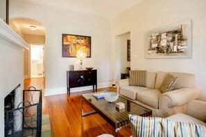 A living room with a sofa, coffee table, and artwork on the walls.