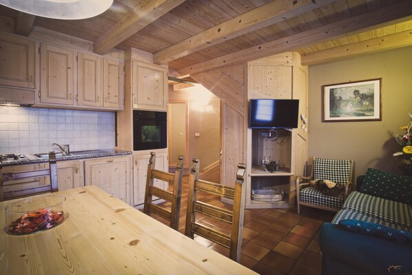 Een houten interieur met keuken, eetruimte en woongedeelte.