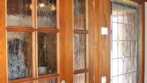 Une porte en bois dotée de plusieurs panneaux de verre et d’une poignée en métal.