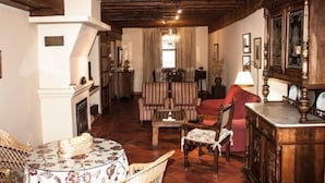 Un salon chaleureux avec une cheminée, des meubles en bois et un lustre.