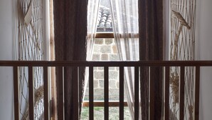 A room with wooden beams, a view through a window with a curtain, and a wooden railing. - Roblejimeno Country House - 2026 Solar Eclipse Special - Solar Eclipse Spain 2026 (Cubillo del Cesar)