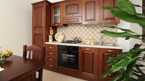 Una cocina con armarios de madera, estufa y pileta.