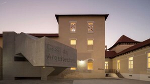 Ein Gebäude mit einem Schild, auf dem „Casa da Arquitetura“ steht, mit modernem Design und einer Betonstruktur im Vordergrund.