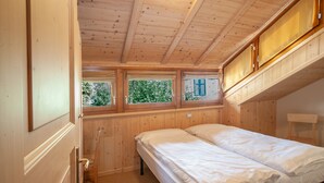 A bedroom with two beds, wooden ceiling, and a window with shutters. - Chalet Terme Bormio - REIT (Bormio)