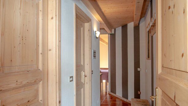 A wooden hallway with tiled flooring and wooden doors. - Chalet Terme Bormio - REIT (Bormio)