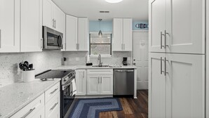 A compact kitchen with white cabinetry, a stainless steel refrigerator, a microwave, and a dishwasher. - Summer Times #4 - 2 Bedroom Located Close To The Beach (NORTH MYRTLE BEACH)