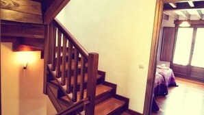 Una escala de fusta amb barana i aplics de llum fixats a la paret.