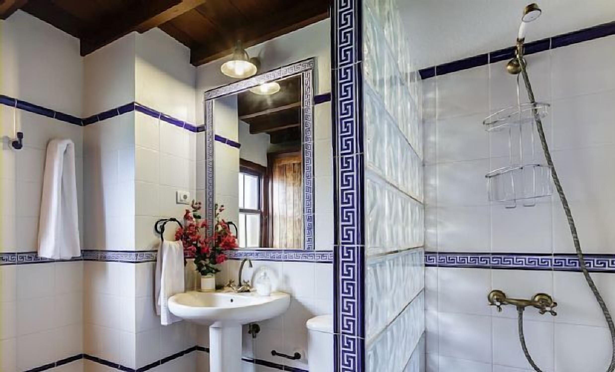 A bathroom with a white sink, mirror, and shower.