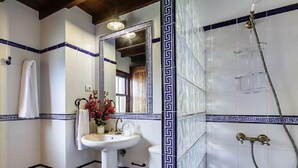 Une salle de bain avec un lavabo blanc, un miroir et une douche.