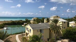 A coastal residential area with houses, a clear sky, and a view of the ocean. - Paradise beach front condo with stunning views. (Flexible cancellations) (Antigua and Barbuda)