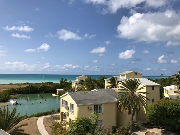 A coastal residential area with houses, a clear sky, and a view of the ocean. - Paradise beach front condo with stunning views. (Flexible cancellations) (Antigua and Barbuda)