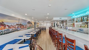 A bar area with a neon sign reading "Chesapeake Bay" and a mural of a cityscape on the wall. - DAILY ACTIVITIES & LINENS INCLUDED*! Direct Plaza Oceanfront 2BR/2BA with Open Den. (Ocean City)
