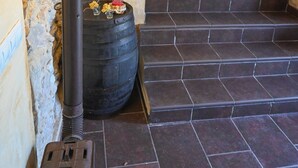 Una escalera con una lámpara y un barril en un interior rústico.
