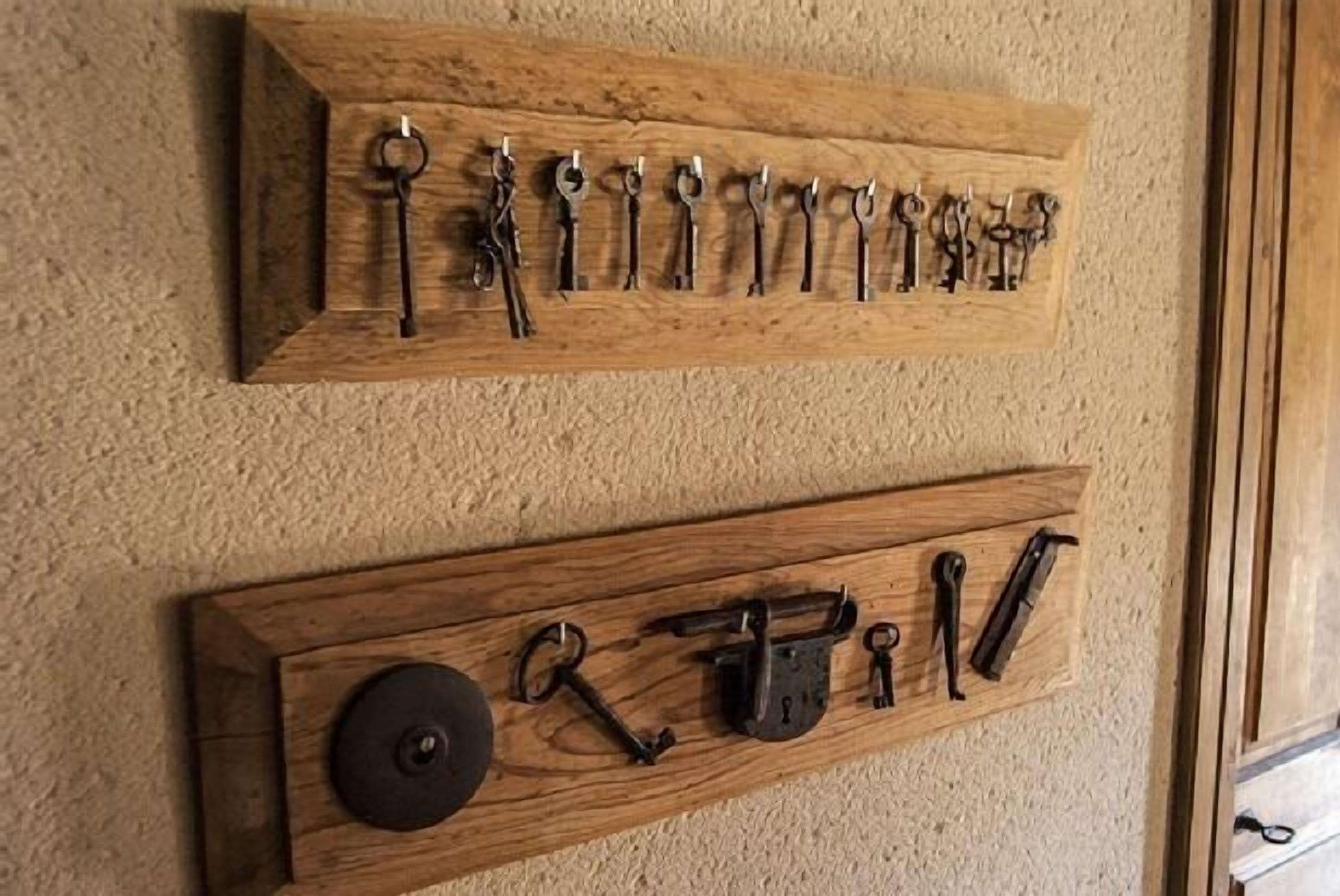 Dos organizadores de herramientas de madera fijados a la pared, con distintas herramientas.