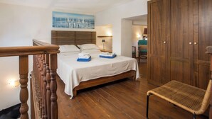 A bedroom with a wooden bed, a chair, a wardrobe, and a painting on the wall. - Spacious sea view studio  ATHENA  for 2-3 persons in Rhodes - Ialysos (Rhodes)