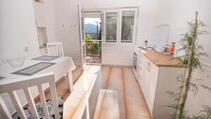 A small kitchen with a dining area, a window with a view, and a plant. - Risan Apartment, Boka Bay (Risan)