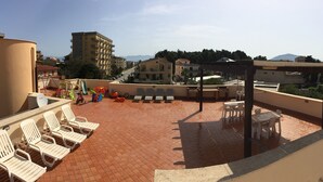 A rooftop terrace with white lounge chairs, a children's play area, and a pergola. - Villa Gelvi. Apartment in villa 2 minutes from the sea (wi fi, solarium, games) (Castellammare del Golfo)
