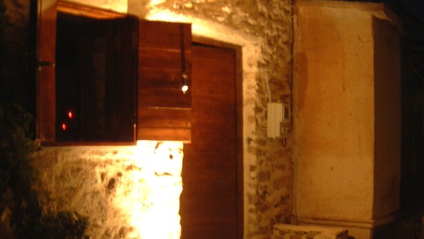 Ein Innenhof mit Steinboden, einer Holztür und Stufen, die zu einer Steinmauer führen.