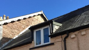A building with a beige exterior, two windows with white frames, and a black gutter running vertically along the side. - March Cottage Terraced Cottage Brecon Brecon Beacons Free Wifi  (Brecon)