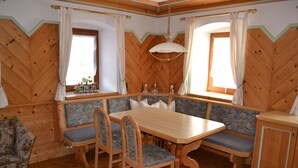Un intérieur en bois avec une table à manger, des bancs et un canapé.