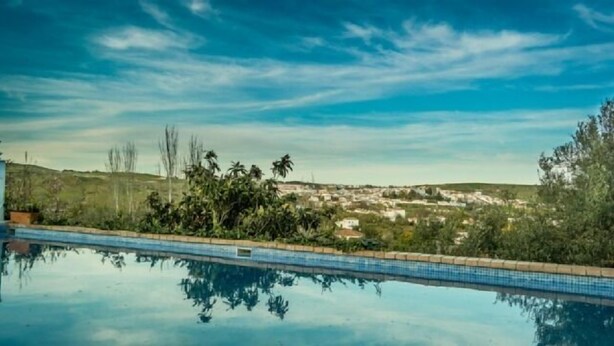 A swimming pool with a clear view of a town in the background.