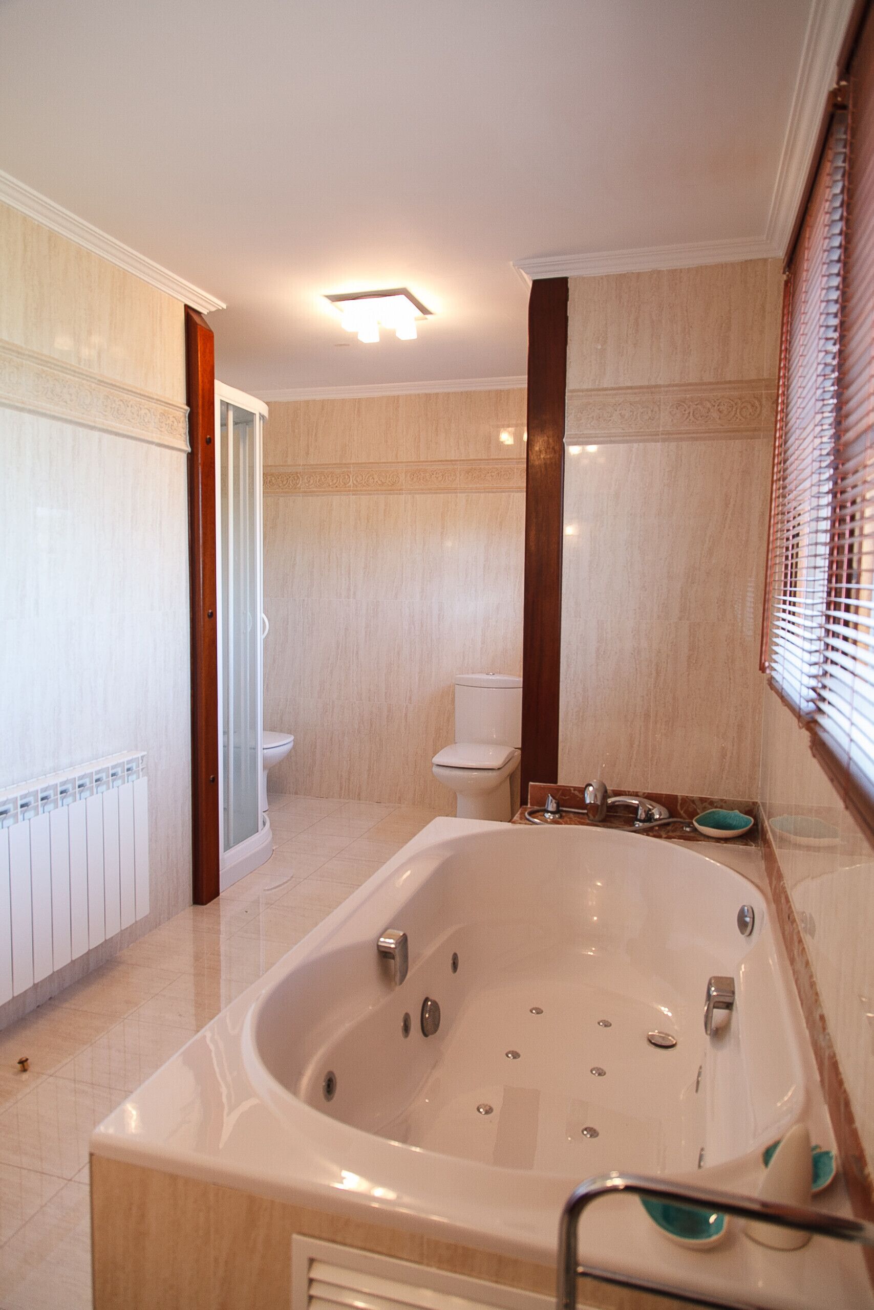 Une salle de bain avec une grande baignoire, des toilettes et un espace douche.