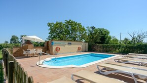 A swimming pool with lounge chairs, a table, and an umbrella. - Self catering Can Salvà for 12 people (Vilobí d'Onyar)