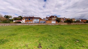 A residential area with houses, a stone wall, and a grassy field. - Meadow View | Witney Holiday Let | 1 Bed & Sleeps 2 (Witney)