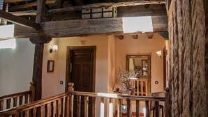 Eine rustikale Holztreppe führt zu einer Veranda mit einer Holztür und einem Spiegel.