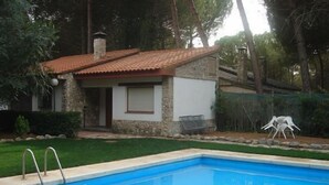 A swimming pool with a stone house in the background. - Country house (full rental) Ribera El Duero for 6 people + 2camas suppl. (Traspinedo)