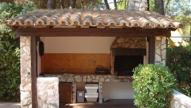 An outdoor kitchen with a stone structure, a tiled roof, and a potted plant. - Country house (full rental) Ribera El Duero for 6 people + 2camas suppl. (Traspinedo)