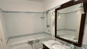 Een badkamer met een bad, een wastafel en een spiegel.