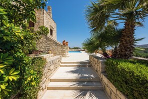 A stone staircase leading to a pool with a clear blue sky above. - Adam Villas - Villa Armonia | An Iconic Destination near to Falassarna Beach. (Chania)
