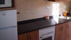 Une cuisine équipée d’un four à micro-ondes, d’une cuisinière et d’un évier.