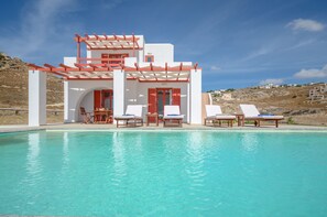 A modern building with a pool, white walls, red accents, and outdoor seating. - DUNES Villa with Private pool for 6 (Naxos)