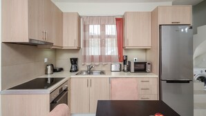 A compact kitchen with light wood cabinets, a stainless steel refrigerator, a microwave, a coffee maker, and a sink. - DUNES Villa with Private pool for 6 (Naxos)