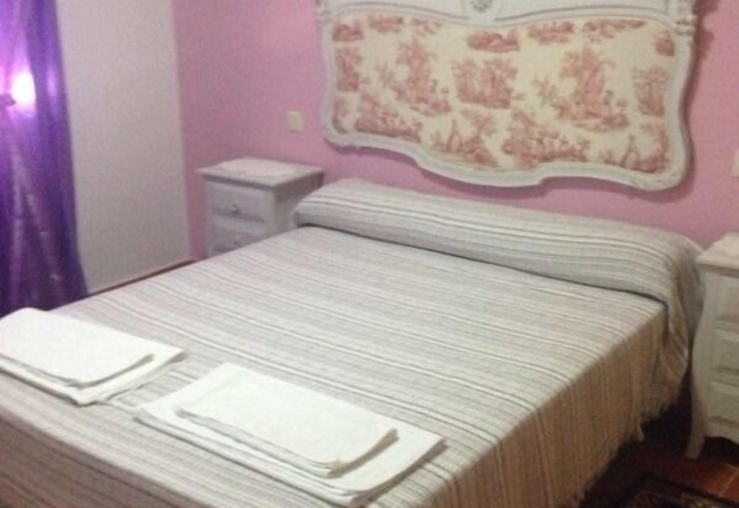 Une chambre à coucher comprenant un lit, une table de chevet et un élément décoratif fixé au mur.