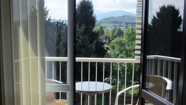 A balcony with a table and chairs, offering a view of a green landscape and distant mountains. - "Les Rousserolles"- Between LAC du BOURGET and CHAMBERY, T 2 (64m2), 3 stars NN (La Motte-Servolex)