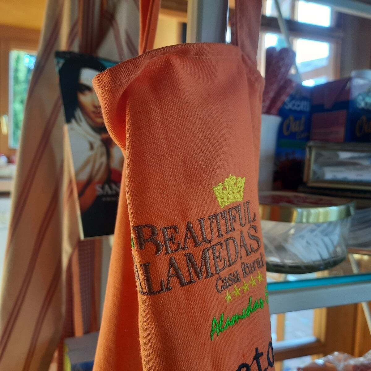 A fabric item with embroidered text, possibly a towel or a piece of clothing, with a visible logo and name.