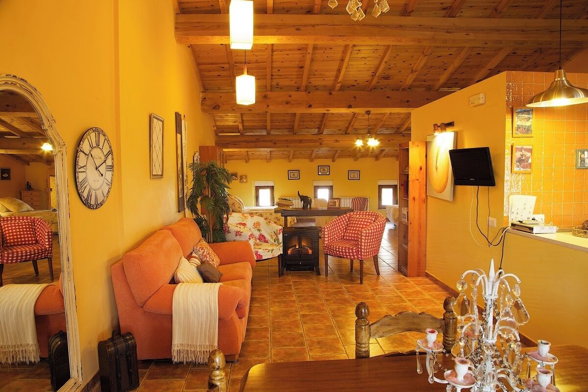 Una sala de estar acogedora con chimenea, un sofá, una mesa de centro y una televisión.