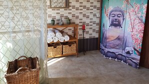 A room with a mosaic wall, a Buddha painting, a shelf with towels, and wicker baskets. - Alojamiento Rural El Valle for 6 people (Dúrcal)