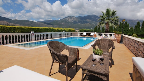 A rooftop pool area with wicker furniture and a view of mountains. - First floor independent apartment with amazing views & private pool in Pessada (Livathos)